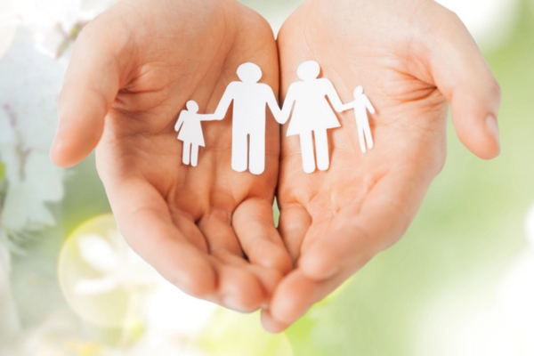 Man hands holding paper cutout of family depicting values