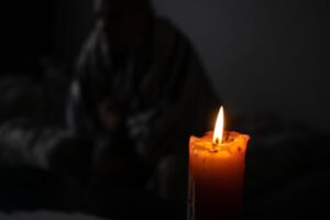 candle with a person in the background depicting power outage