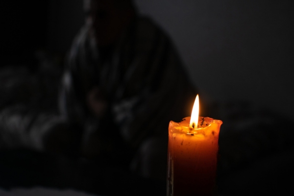 candle with a person in the background depicting power outage