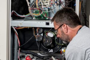 HVAC technician tending to a furnace