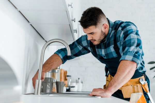 plumber fixing kitchen faucet handle