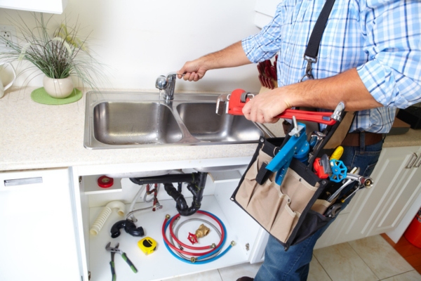 plumber inspecting kitchen faucet