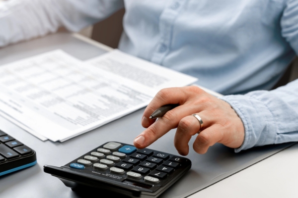 man using calculator while evaluating propane requirements