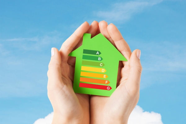 hand holding a house cutout with energy efficiency chart depicting heating oil efficiency