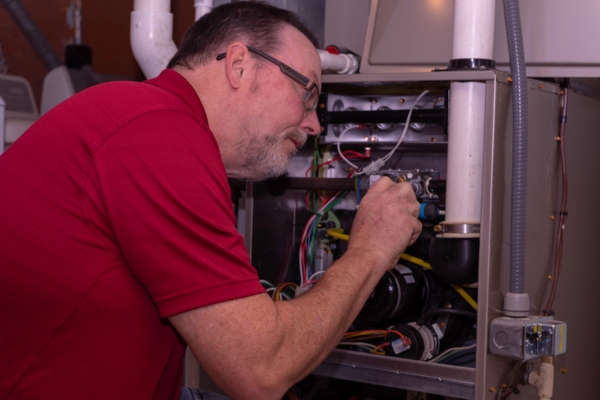 professional HVAC technician tending to a furnace