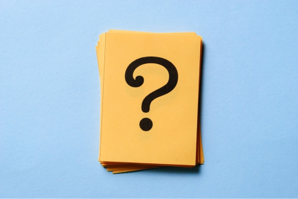 question mark on a stack of yellow paper depicting Automatic vs Will Call Propane Delivery FAQs