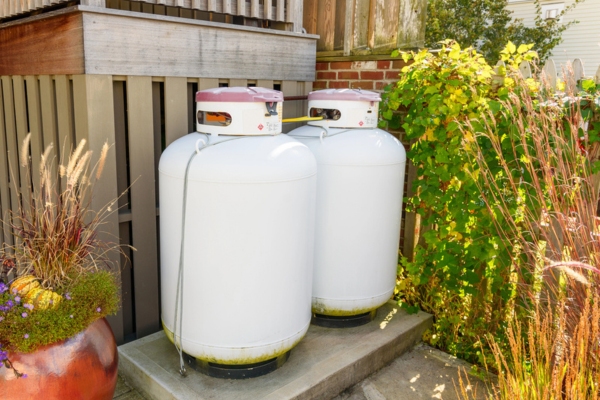 propane tanks on a concrete pavement with plants around