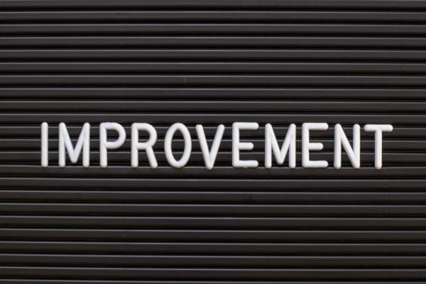 Improvement spelled using plastic letters on a felt board depicting energy efficiency