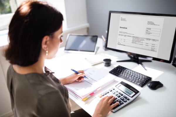 homeowner calculating oil invoice received on her computer