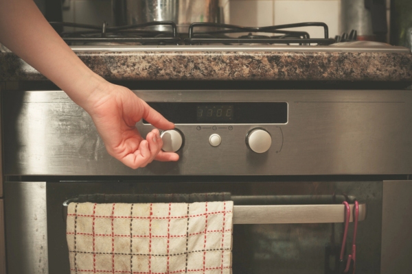 woman's hand adjusting heat using propane oven