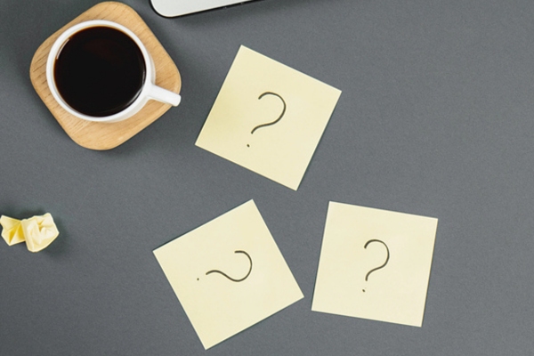 question marks on sticky notes beside a coffee cup depicting Propane Summer Heat FAQs