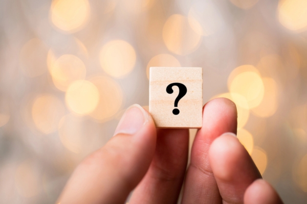 hand holding wooden letter chip with a question mark depicting Water In Oil Tank FAQs
